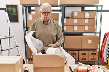 Wall Mural - Senior caucasian man working at small business ecommerce packing order skeptic and nervous, frowning upset because of problem. negative person.