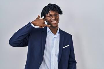 Sticker - Young african man with dreadlocks wearing business jacket over white background smiling doing phone gesture with hand and fingers like talking on the telephone. communicating concepts.