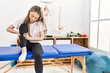 © Krakenimages.com - Young chinese woman with pain on leg sitting on board at clinic