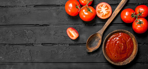 Poster - Tomato sauce in bowl with spoon and ripe tomatoes.