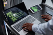 © Seventyfour - High angle close up of network engineer or hacker using laptop with green code lines in server room, copy space
