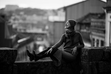 Sticker - A woman sits an downtown in Porto, Portugal. Black and white photo.