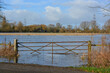 © Lara Red - A view on a flooded field in rural Oxfordshire in winter. A gate to the farmland is under water after heavy rainfall.