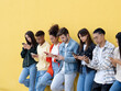 © gonzagon - Group of diverse students chat and watch digital content on mobile phones. Concept of addiction to technology and social networks