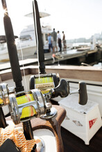 A View Of Fishing Poles At The Dock With Fisherman Talking In The Background.