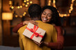 © Prostock-studio - Thankful black woman with christmas gift hugging husband at home