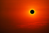 Fototapeta Kosmos - Total solar eclipse on clear red orange sky sunset in the evening