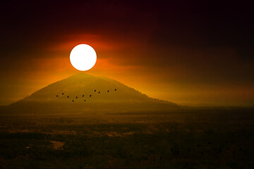 Wall Mural - sunset on morning sky over hill and mountain and silhouette bird flying