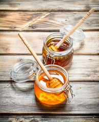 Wall Mural - Fresh honey in a glass jar with a spoon.