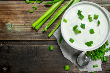 Sticker - Fresh sour cream in bowl with green onions .