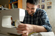 © Westend61 - Smiling man using sewing machine at home
