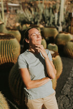 Smiling Woman With Eyes Closed Standing In Cactus Garden