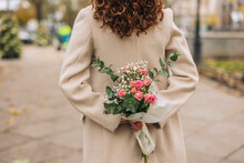 Young Woman Holding Bouquet Of Flowers At Footpath