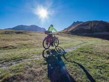 Man Riding Mountain Bike On Sunny Day Under Blue Sky At Vanoise National Park, France