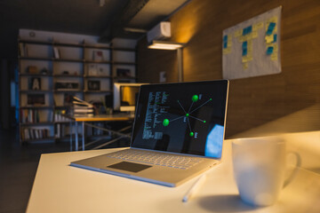 Diagram and data on laptop screen at desk in office