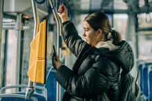Teenage Girl Buying Ticket Through Smart Phone In Tram