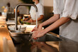 © Drobot Dean - Young chef woman washing hands while working in restaurant kitchen
