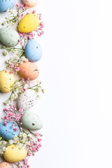 easter quail eggs and springtime flowers over white background. spring holidays concept with copy sp