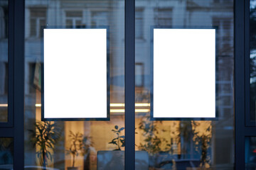 Blank window poster template. Promotional banner on the store, office window mock up. Blurred background, selective focus, copy space