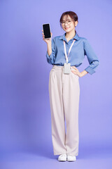 Wall Mural - Photo of young Asian businesswoman holding smartphone on background