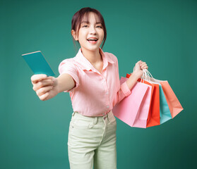 Poster - Image of young Asian girl holding shopping bag on background