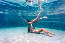 Underwater View Of Two Women In Swimming Pool