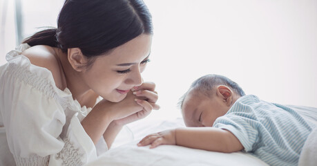 Wall Mural - Close up portrait of beautiful young asian mother with her newborn baby, copy space with bed in the hospital background. Healthcare and medical family love lifestyle nursery mother’s day concept