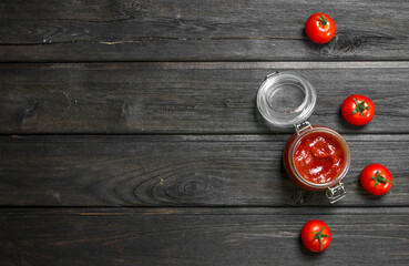 Sticker - Tomato sauce in a glass jar and fresh tomatoes.