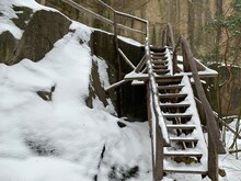 Wooden Steps Near The Cliff. Staircase Made Of Wood In The Snow. Wooden Structure For Climbing The Mountain.