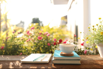 Coffee cup and pot and daisy flower on wooden table outdoor