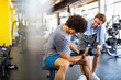 © NDABCREATIVITY - Fit man working out in gym with personal trainer to stay healthy. Sport, people concept
