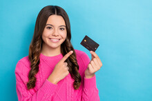 Photo Of Funky Charming Lady Wear Pink Sweater Pointing Finger Bank Card Empty Space Isolated Blue Color Background