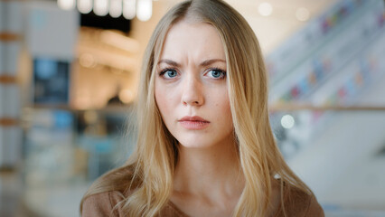 Close-up female face indoors portrait blond 20s girl millennial woman lady confused female looking at camera with interest searching someone listening attentively waiting puzzled expression emotions