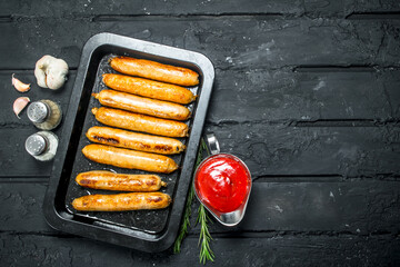 Canvas Print - Fried sausages with garlic, spices and tomato sauce.