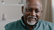 © Yuliia - Male portrait indoor African elderly grandfather at home looking at camera with friendly smile. Old business worker in office company CEO mature senior American man ethnic businessman elder generation