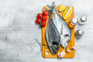 Sticker - Raw sea fish dorado with tomatoes, lemon wedges and spices.