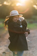 Mujer joven con cachorro de golden retriver posando feliz al atardecer en el campo