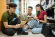 © DragonImages - Group of students sitting in library floor and discussing school project