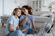 © DimaBerlin - Happy overjoyed mother and teen daughter enjoying refreshing fresh breeze from electrical fan, smiling joyful mom and child having fun at home, sitting on floor near air cooler in cozy living room