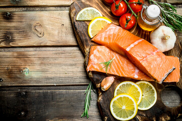 Wall Mural - Raw salmon fish filet with lemon, tomatoes and herbs.