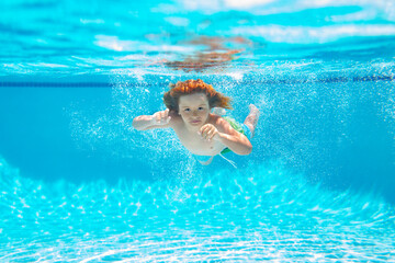 Kid swimming underwater on the beach on sea in summer. Blue ocean water. Child boy swimming in sea.