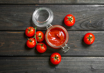 Poster - Tomato sauce in a jar with ripe cherry tomatoes.