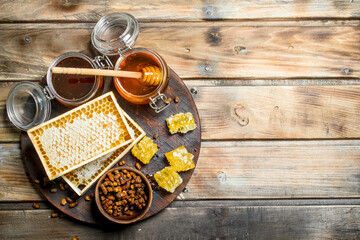 Wall Mural - Honey in glass jars and honeycombs on the Board.