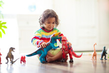 Child Playing With Toy Dinosaurs. Kids Toys.