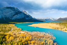A Drone View Of The River In The Mountains Valley. An Aerial View Of An Autumn Forest. Winding River Among The Trees. Turquoise Mountain Water. Landscape With Soft Light Before Sunset.