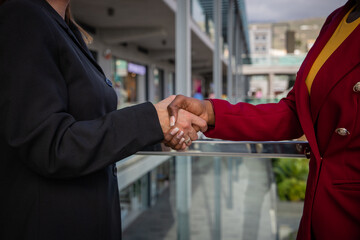 Two businesswomen, caucasian and african shaking hands, done deal concept.