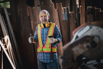 Wall Mural - An elderly carpenter works the wood with meticulous care.