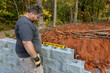 Following leveling of walls on construction site retaining wall contractor installed concrete block.