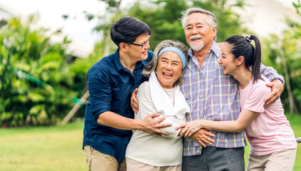 Portrait enjoy happy smiling love multi-generation asian big hug family.Senior mature father and elderly mother with young adult woman and son outdoor in park at home.insurance concept