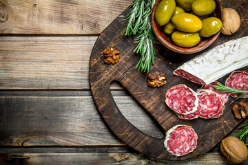 Wall Mural - Salami with olives and a sprig of rosemary